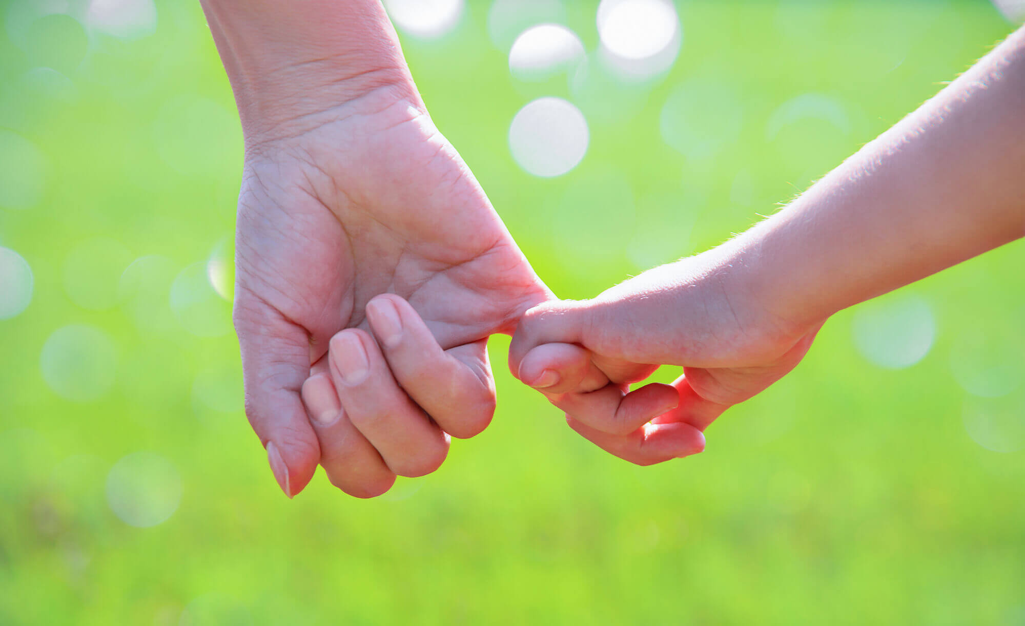 child holding hands with adult