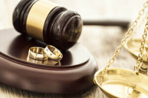 Divorce concept with gavel and wedding rings