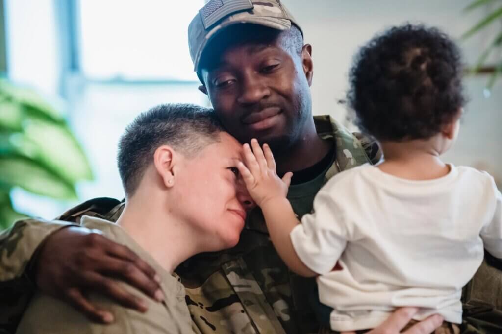 Military man hugging his family